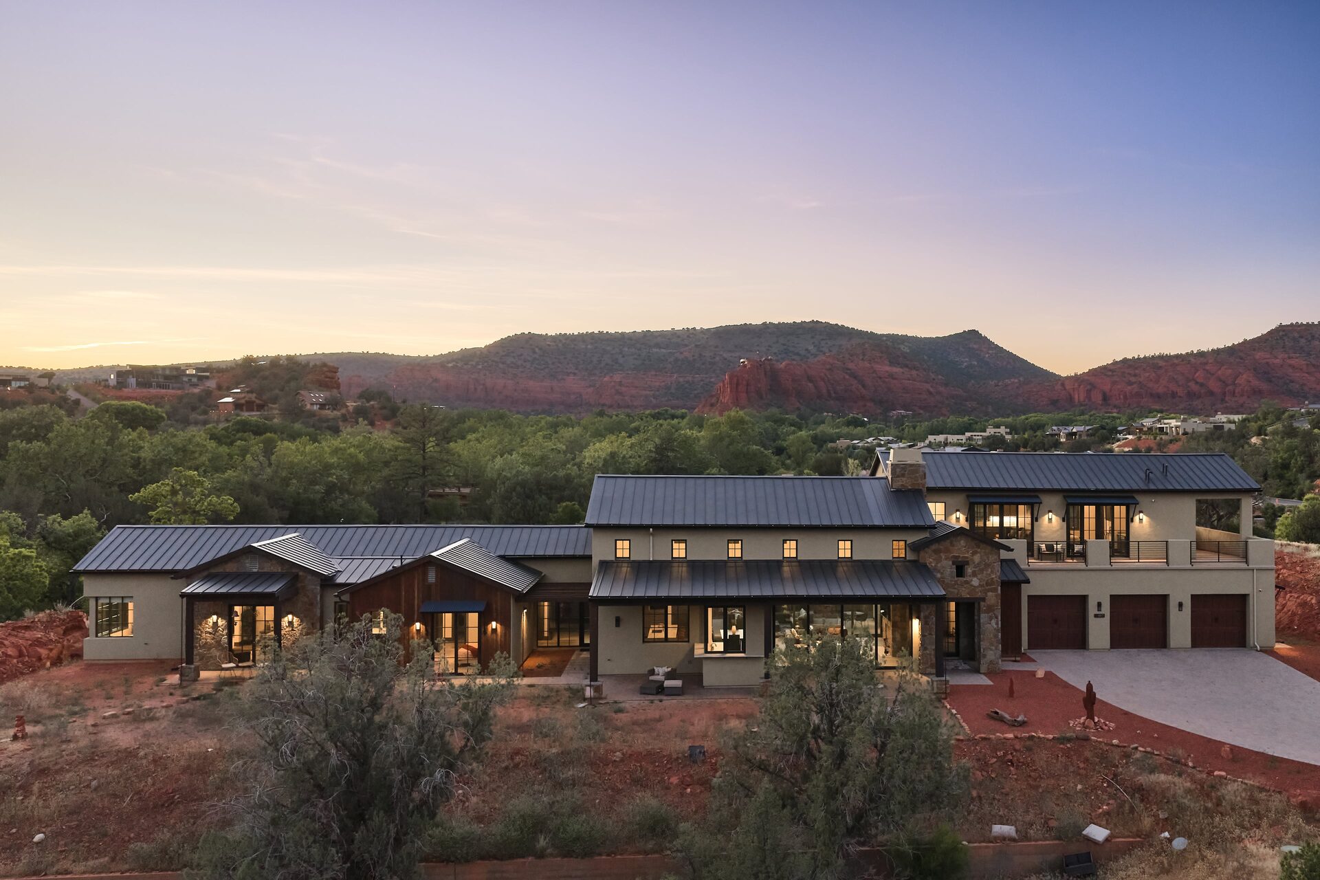 407 Loy Lane — estate at dusk against Sedona red rock